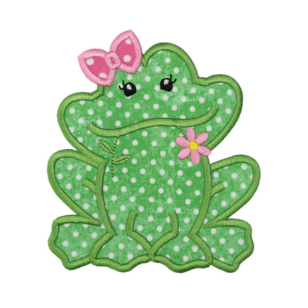 Green polka dot frog embroidered patch with white spots, pink bow on head, pink flower accent on chest, black stitched eyes with lashes, satin stitch border and applique style design for iron on or sew on application.
