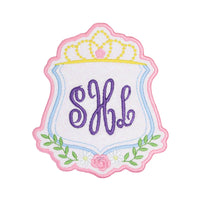 Princess crown crest monogram embroidered patch with scalloped pink border, pastel shield frame, floral accents, and custom script initials, perfect for personalized backpacks, jackets, dresses, and boutique accessories