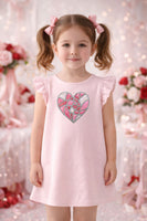 Young girl wearing a pink dress with a heart design 
