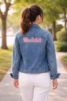 Blue denim jacket with 'Wanderlust' text patch