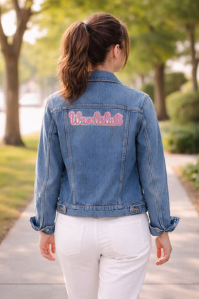 Blue denim jacket with 'Wanderlust' text patch